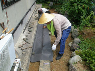 石に防草シートをかぶせる